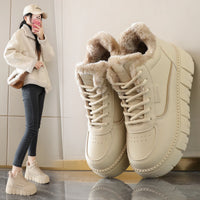 Beige winter boots with fur lining on a reflective surface, with a person wearing similar boots in the background.