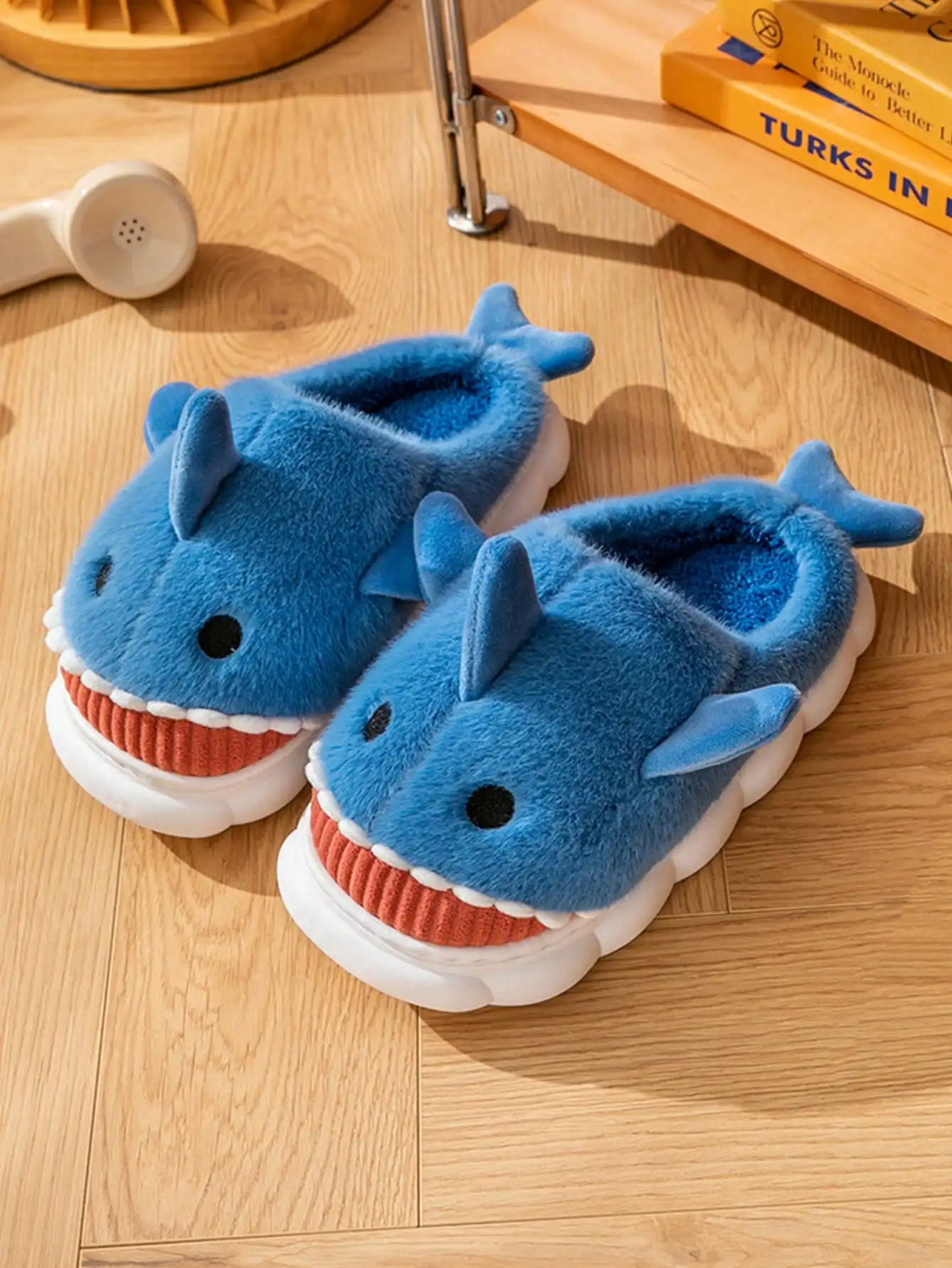 Side view of cartoon shark slippers showing playful shark motif detail