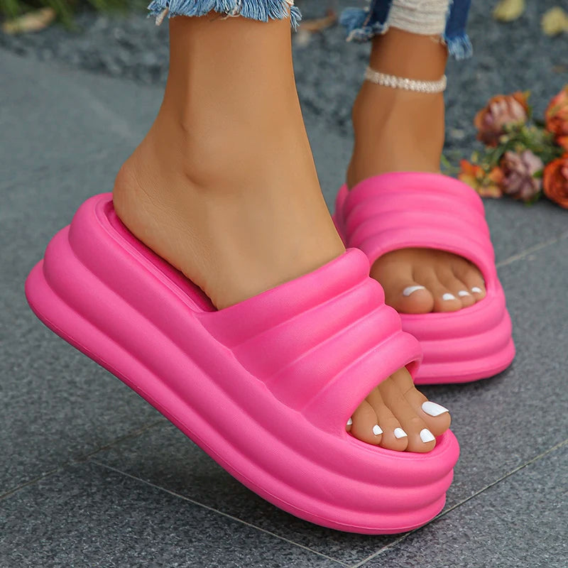 Pink slippers worn on feet with a blurred background