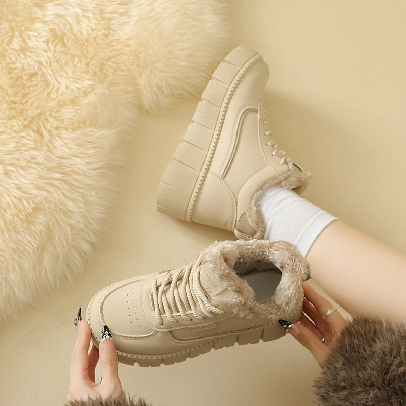 Beige winter boots with fur lining worn by a person on a beige background