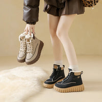 Person holding a pair of beige boots with black and brown boots on a beige background