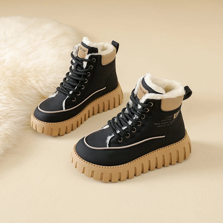 Black high-top boots with beige soles on a beige background