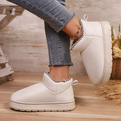 Woman wearing EvaCozy warm winter slippers at home in Canada