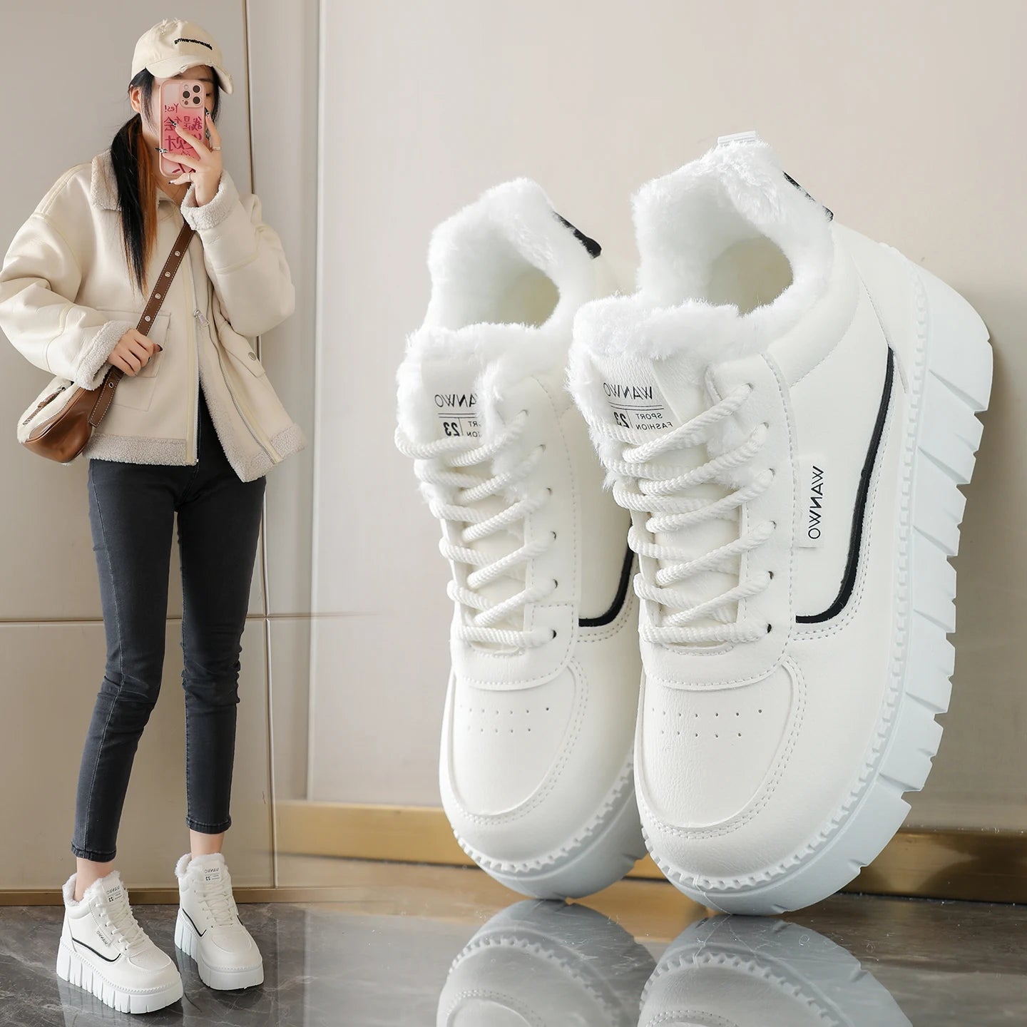 White sneakers with black accents on a reflective surface, next to a person wearing similar shoes indoors.